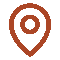 A simple graphic icon representing a location pin in a red color. The icon consists of an outer teardrop shape with a circular inner marking, commonly used to indicate points of interest on maps.